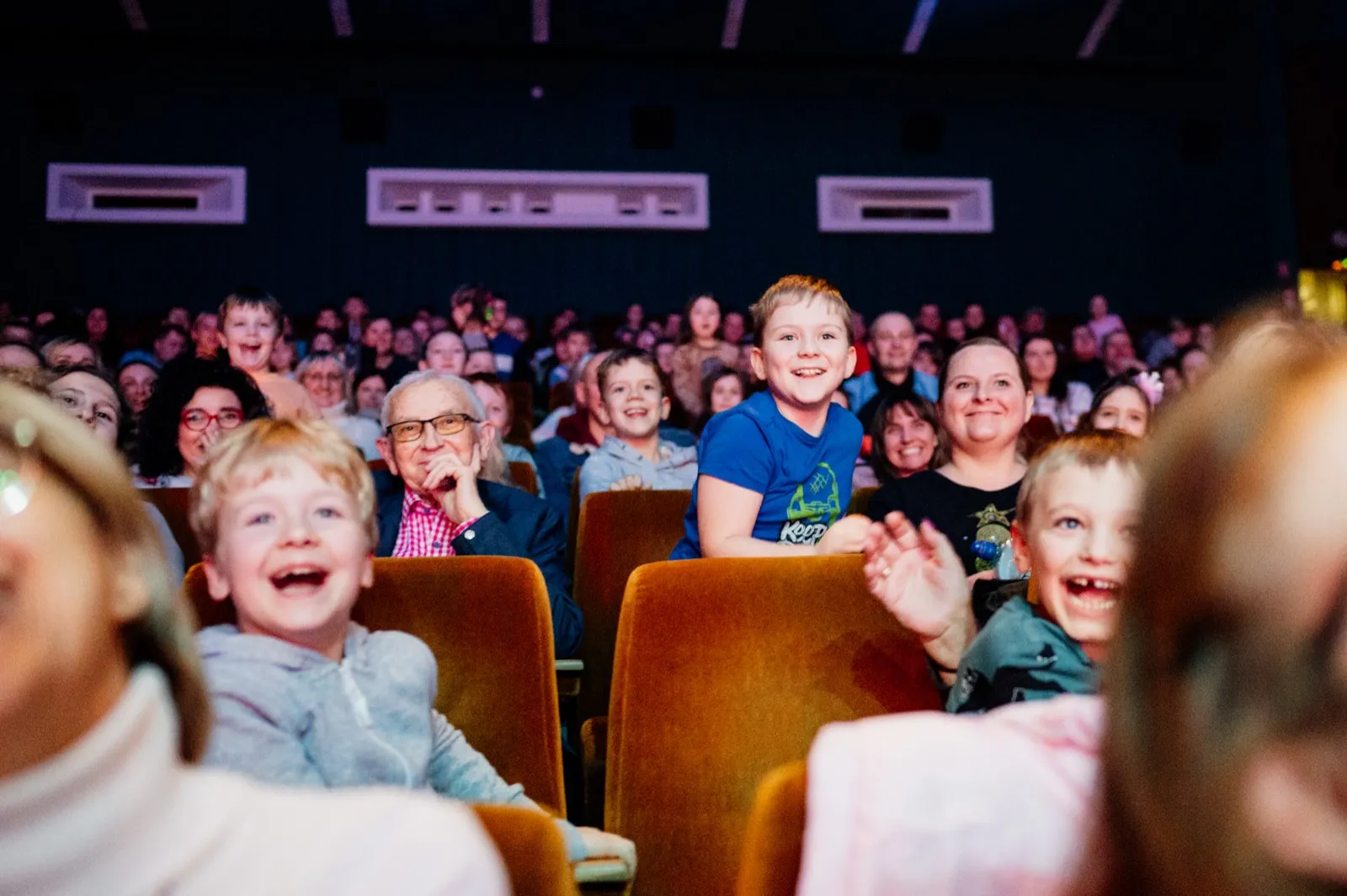 Roześmiane dzieci w pierwszych rzędach widowni podczas Magiczni SHOW