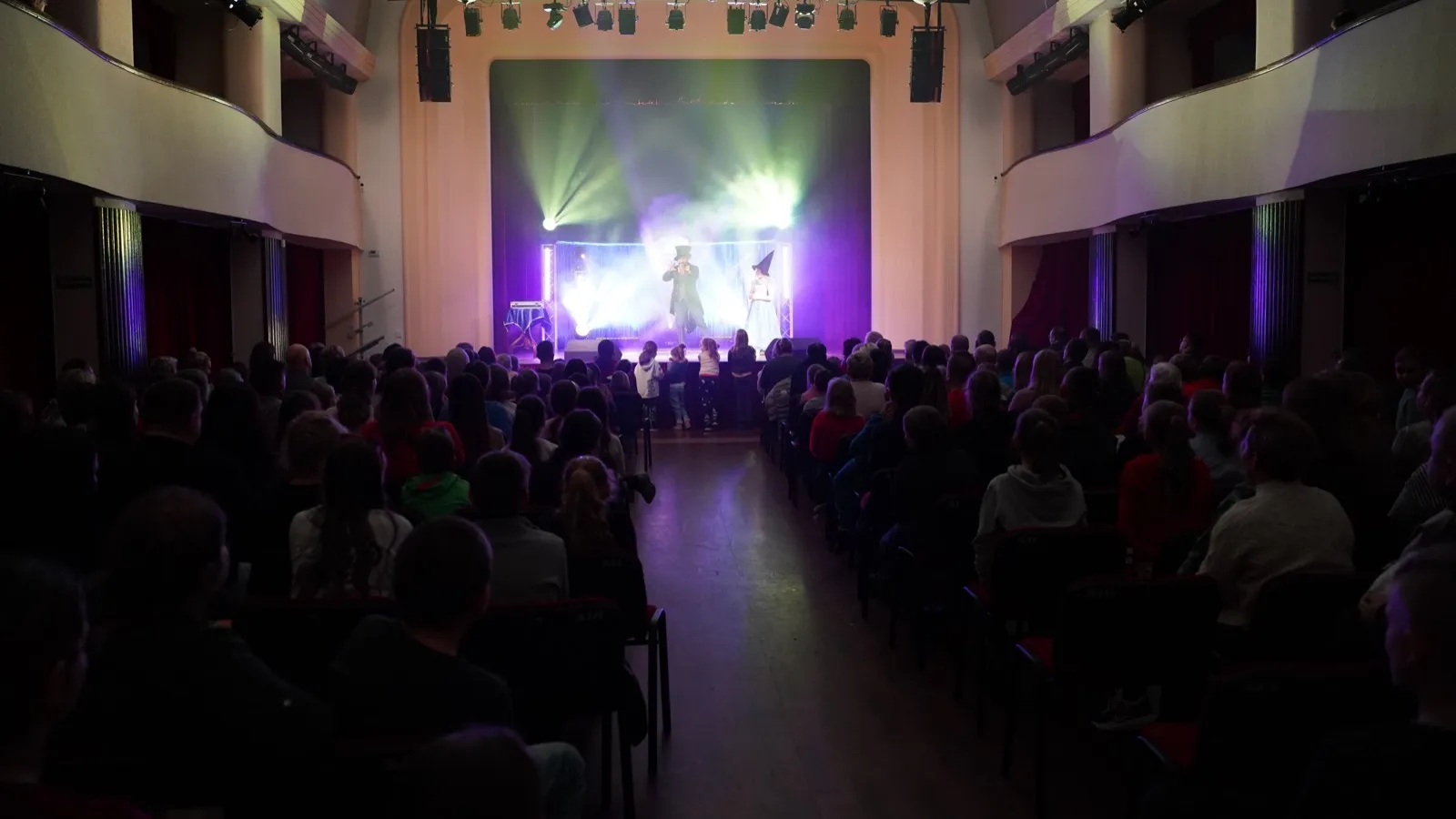 Spektakl iluzji w auli szkolnej — dzieci oglądają występ Magicznych